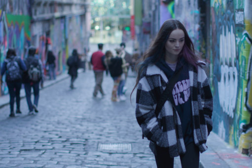 Eleanor Chadwick walks along Melbourne’s Hosier Lane in the music video for the Pop Choir single <i>Windows With Smiles.<i>
