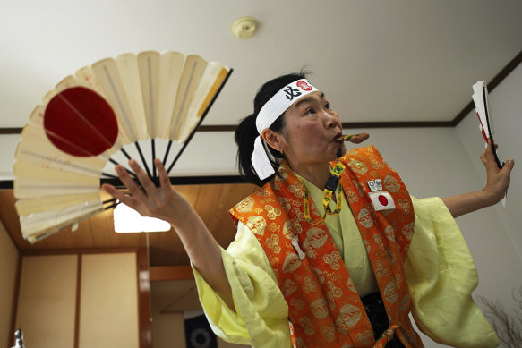 Olympic fan Kyoko Ishikawa, who has become somewhat famous in Japan as an unofficial Olympic cheerleader, will have to cheer from afar. Her headband says “Win!” 