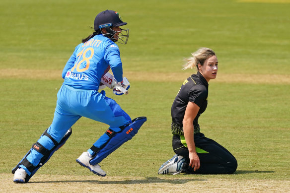 India's Smriti Mandhana, left, runs between the wickets as Australian bowler Ellyse Perry, right, looks on.  