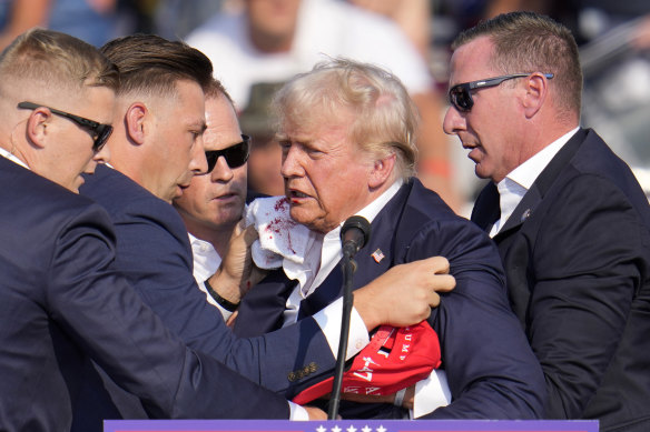Donald Trump is helped off the stage after the assassination attempt on Saturday.