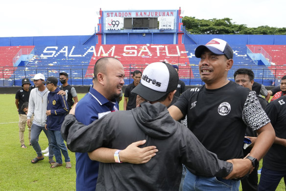 Arema fans and officials embrace inside the stadium on Monday.