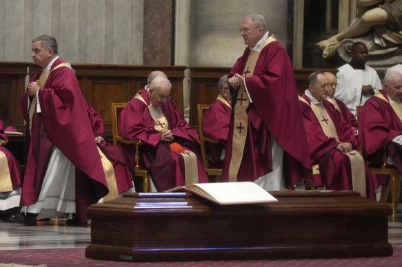 Cardinal Angelo Becciu (left) walks past the coffin of Australian Cardinal George Pell during the funeral ceremony in St. Peter’s Basilica, at the Vatican.