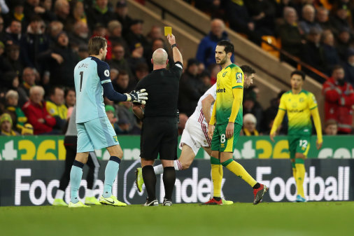 Sheffield United's Chris Basham sees yellow after his red card is overturned by VAR.