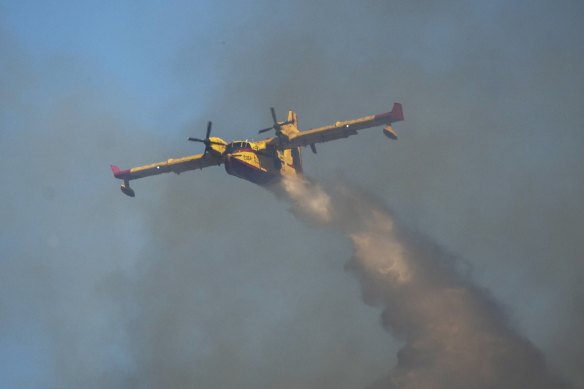 A Canadair aircraft drops water over a wildfire in Vati village, on the Aegean Sea island of Rhodes, southeastern Greece.