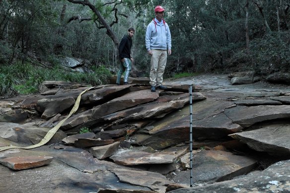 Environment groups say the "shattering" of Redbank Creek caused by mine subsidence will likely be extended to two other creeks in the region if Tahmoor Colliery's expansion plan is approved. Pictured is Western Sydney University's Ian Wright (right) and Callum Fleming, one of his students.