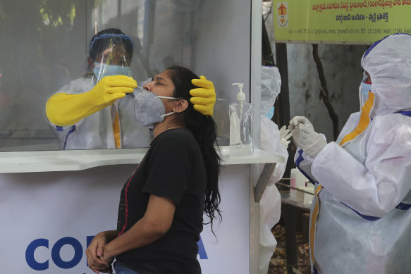 A health worker takes a nasal swab sample to test for COVID-19 in Hyderabad, India.