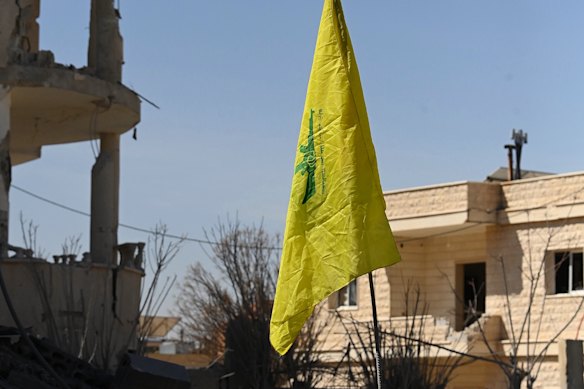 Uma bandeira do Hezbollah entre as ruínas de uma casa em Douris.