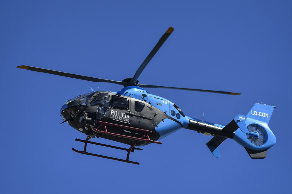A police helicopter, with Lionel Messi aboard, flies over the gathered fans.
