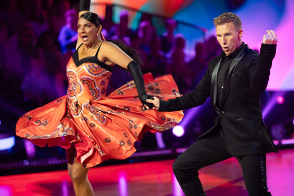 Nova Peris, with dance partner Craig Moloney, in her tangerine jive dress by Indigenous designer Paul McCann.