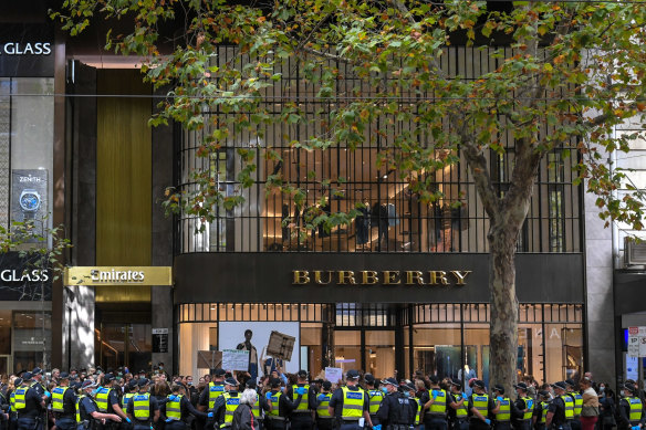 Police surround protesters outside the Victorian Liberal Party headquarters. 
