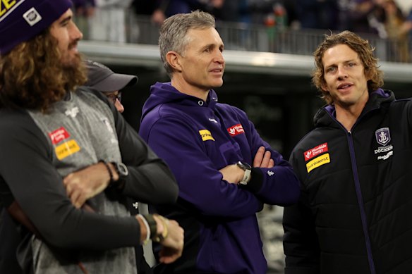 Justin Longmuir (centre) speaks with Dockers skipper Alex Pearce (left) and former captain Nat Fyfe (right) at Optus Stadium.