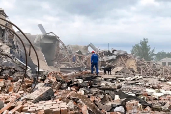 An Emergency Ministry employee and his dog work at the side of the Zagorsk Optical and Mechanical Plant after the blast in the city of Sergiev Posad, Moscow Region on Wednesday.
