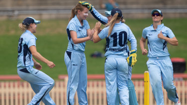 Lauren Cheatle is congratulated by the Breakers after taking a wicket in last season's WNCL final.