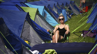 A festivalgoer sits in the sunshine amongst tents at the Glastonbury Festival in England on Friday.