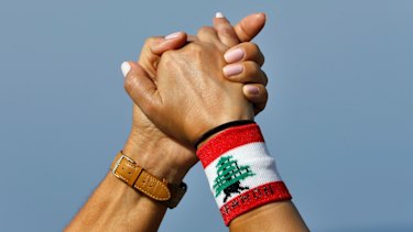 Thousands of Lebanese have formed a human chain along highways and coastal roads to link Beirut and other cities in a show of solidarity with the anti-government protests.