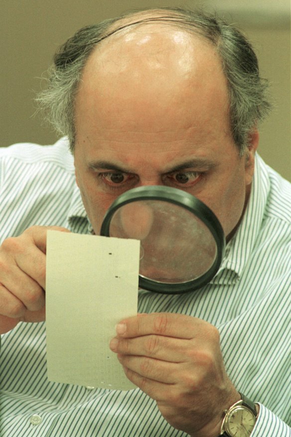 Judge Robert Rosenberg of Broward County Canvassing Board uses a magnifying glass to view a dimpled chad (the bit of paper pushed out when a hole is punched) on a punch-hole ballot in 2000, during a recount of votes in Fort Lauderdale, Florida. 