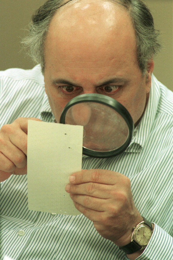 Judge Robert Rosenberg of Broward County Canvassing Board uses a magnifying glass to view a dimpled chad (the bit of paper pushed out when a hole is punched) on a punch-hole ballot in 2000, during a recount of votes in Fort Lauderdale, Florida. 