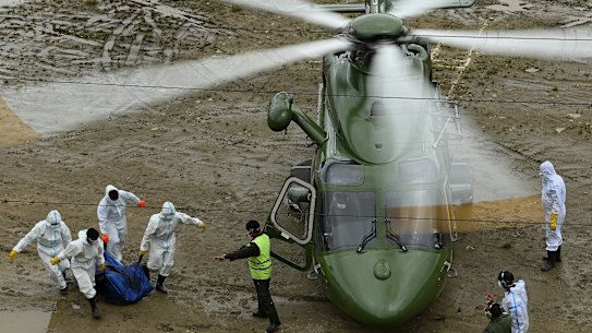 La polizia nepalese trasporta i corpi su un elicottero diretto a Chitwan, dove vengono sepolte centinaia di vittime del disastro.