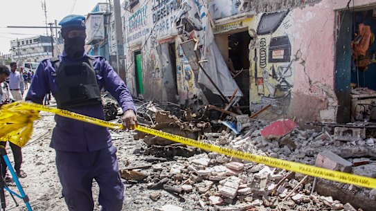 A member of security forces cordons off wreckage at the scene.