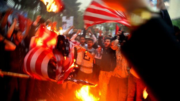 Iranian demonstrators burn representations of the US flag during a protest in front of the former US Embassy after Donald Trump pulled the US out of the nuclear deal.