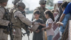 A US Marine opens a meal ready-to-eat package for children during an evacuation at Hamid Karzai International Airport in Kabul. 