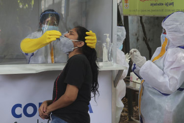 A health worker takes a nasal swab sample to test for COVID-19 in Hyderabad, India.