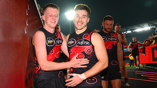 Angus Clarke of the Bombers celebrates his first game and win with Zach Merrett.