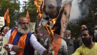 Protesters burn pictures of Meena Harris and Greta Thunberg, who criticised the government for its handling of recent demonstrations.