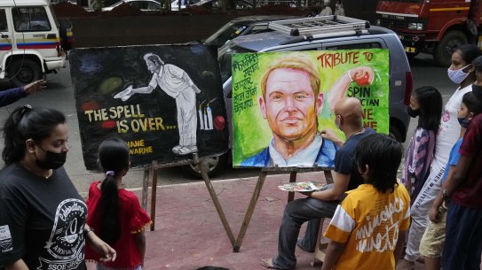 Indian artist Sagar Kambli makes a painting of Australian cricketer Shane Warne as a mark of tribute  on a sidewalk in Mumbai, India.