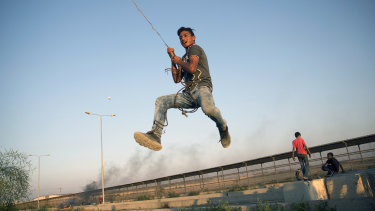 A Palestinian protester swings from a hanging metal cable during a protest at the entrance of Erez border crossing between Gaza and Israel, in the northern Gaza Strip last week.