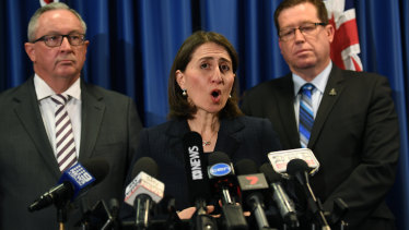 Premier Gladys Berejiklian, with Health Minister Brad Hazzard, left, and Police Minister Troy Grant, right. 
