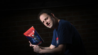 Adam Woolcock with his book, The Last Hurrah, about Melbourne’s 1964 premiership win. 