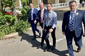Zachary Rolfe (without jacket) leaves court flanked by NT Police Association president Paul McCue (right) and Police Federation of Australia president Ian Leavers (second from left).