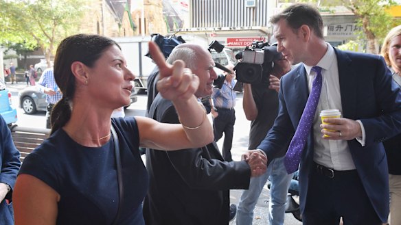 Labor candidate Sam Crosby jumps in and shakes hands with John Howard in Burwood. 