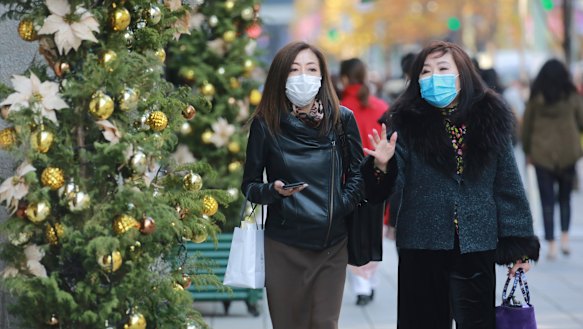 Shoppers wear face masks to help curb the spread of the coronavirus in the Ginza shopping district in Tokyo today.