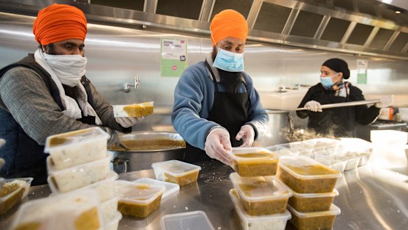 Manpreet Singh, centre, helps serve up meals at Devon Meadows.