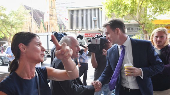 Liberal candidate for Reid Fiona Martin (left) on a street walk in Burwood with John Howard, who is interrupted by Labor candidate Sam Crosby.