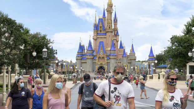 Visitors wear masks at Disney World, which reopened in Florida at the weekend despite climbing COVID-19 cases.