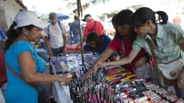 Daixy Aguero, left, sells makeup at a market in Caracas, Venezuela.