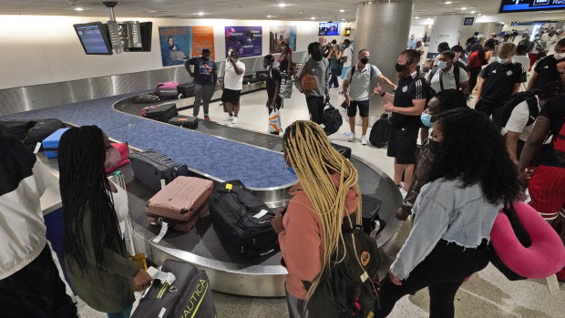 Life returning to normal: travellers wait for their luggage at a baggage carousel at Miami International Airport.