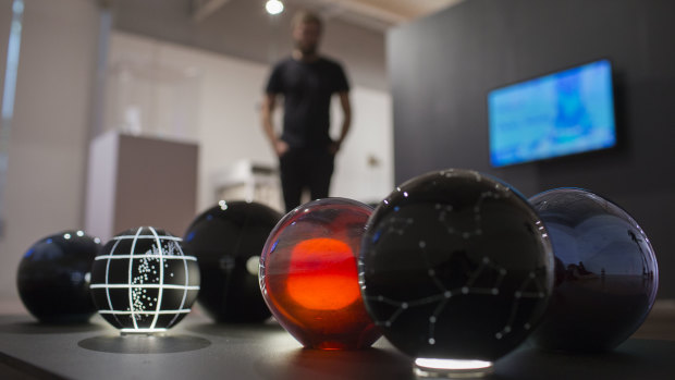 A visitor views Emeirely Nucifora-Ryan's constellation themed glass globes at the ANU School of Art and Design 2018 Graduating Exhibition. 