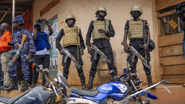 Security forces stand outside a polling station in Kampala on Thursday.
