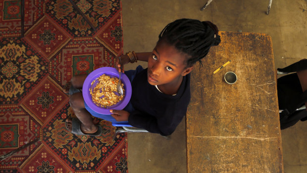 A child eats a meal received from a government sponsored feeding scheme at the Delta Primary School in Vosburg, South Africa.