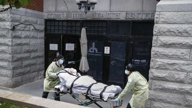 A patient is wheeled out of the Cobble Hill Health Centre by emergency medical workers in the Brooklyn borough of New York.