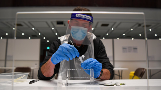 A worker tests a COVID-19 sample in Portsmouth, England. 