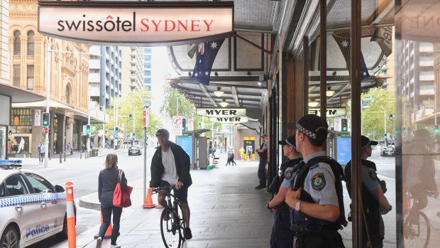 Police guard the Swissotel on Market Street in Sydney, which is being used to quarantine Australians returning to the country by plane.