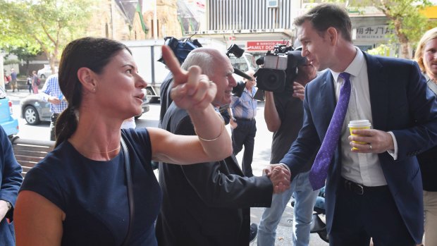 Labor candidate Sam Crosby jumps in and shakes hands with John Howard in Burwood. 