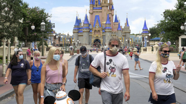 Visitors wear masks at Disney World, which reopened in Florida despite climbing COVID-19 cases.