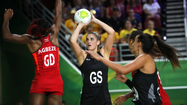 Te Paea Selby-Rickett of New Zealand, centre, and Ama Agbeze of England, left, compete during the preliminary round netball game.