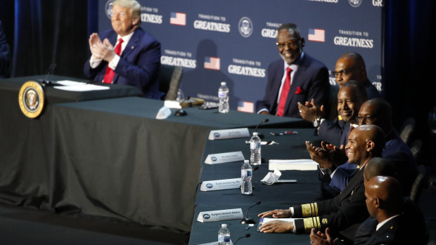 President Donald Trump applauds as US Surgeon General Jerome Adams speaks during a roundtable discussion at Gateway Church Dallas.